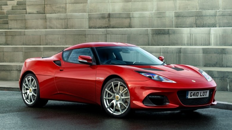 Red Lotus Evora parked in front of concrete structure