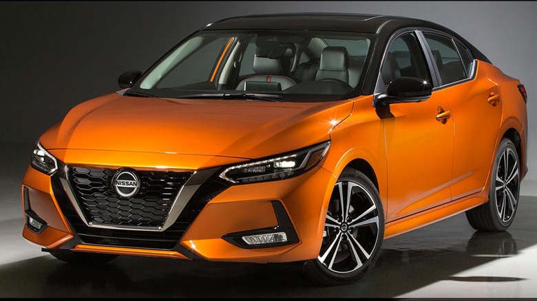 An 2020 orange Nissan Sentra displayed in a studio setting under focused lighting.