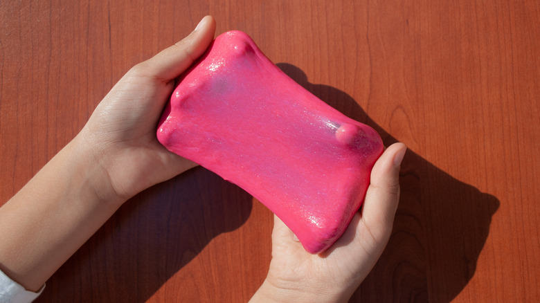 Hands stretching red putty