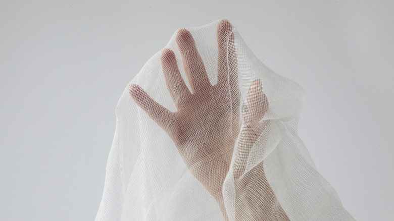 Hand draped with cheesecloth