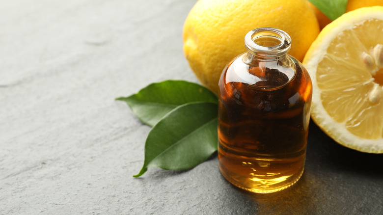 Bottle of oil next to lemons