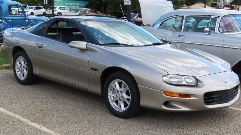 Light brown Chevrolet Camaro Z28 with black hood in a parking lot