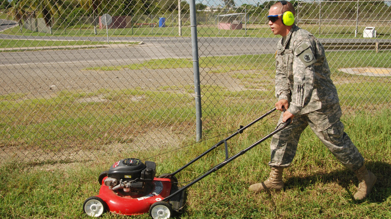 Soldier using a lawnmower to mow the lawn