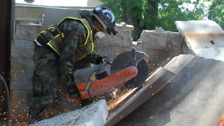 Marine using a rotary saw to cut through some metal