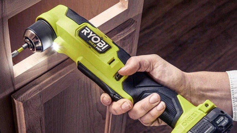 person using right angle drill on cabinet