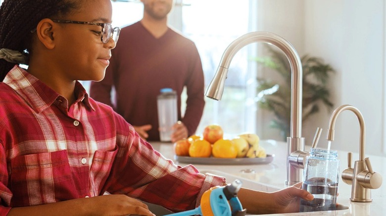 Child getting water from hot water dispenser
