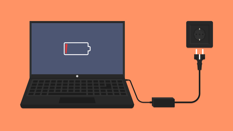 A laptop with a low-battery warning connected to a charger