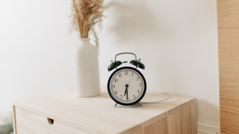 Old-fashioned alarm clock on a wooden dresser