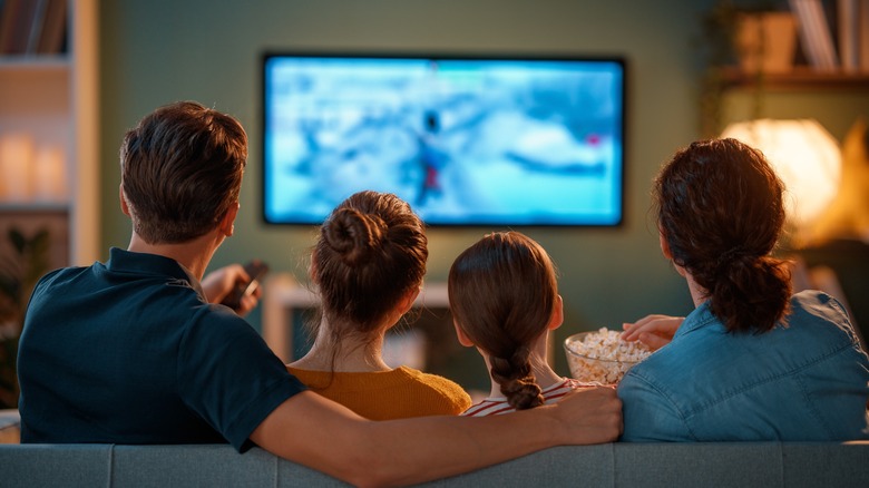 A family of four watching TV