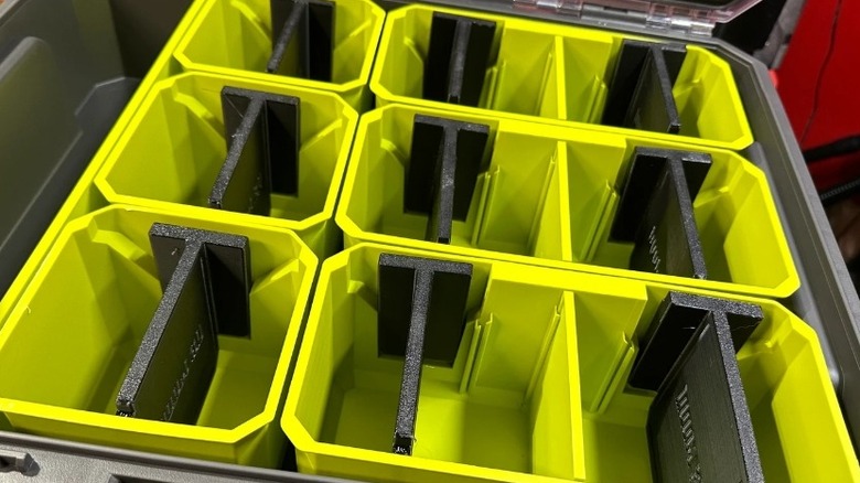 Collection of green storage bins with black dividers