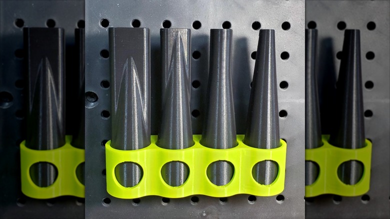 Set of four black nozzles on a wood floor