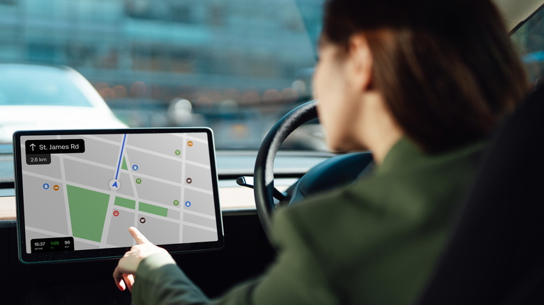 Woman using touchscreen display for maps in car