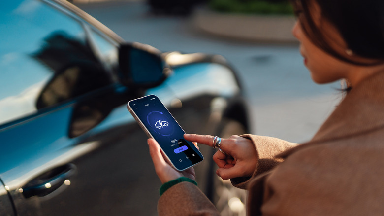 Woman starting electric car from phone