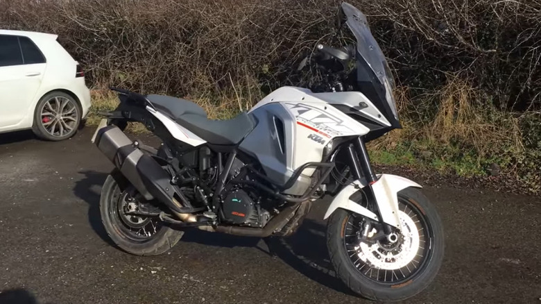 A side view of a white 2017 KTM 1290 Super Adventure T parked outdoors.