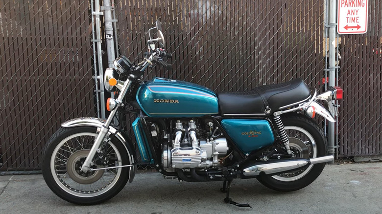 A blue 1975 Honda Goldwing Gl1000 parked at the side of an alley