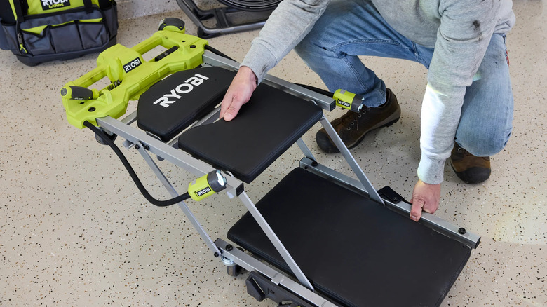Man adjusting the Ryobi creeper/seat