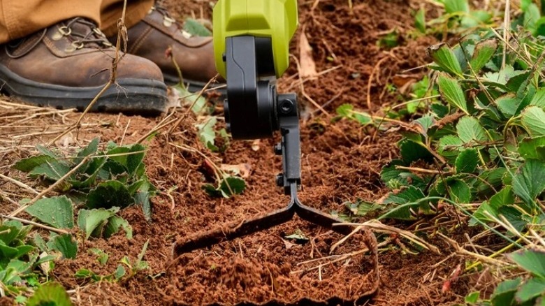 Garden tool moving dirt on the ground