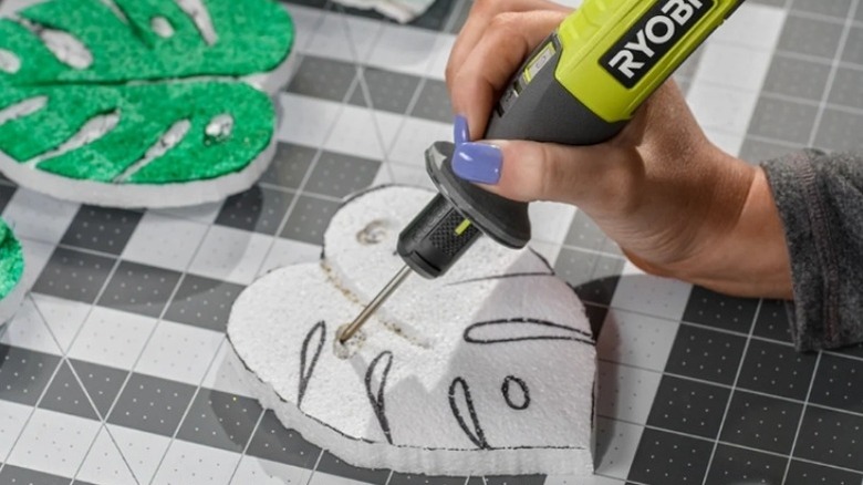 Hand drawing a design into a leaf-shaped piece of foam