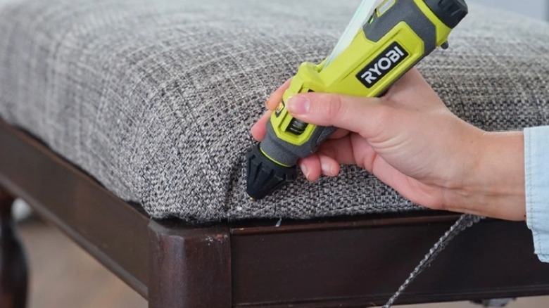 Hand gluing a piece of fabric to furniture