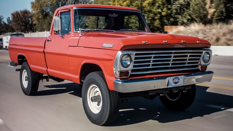 Rangoon Red Ford truck driving down a road