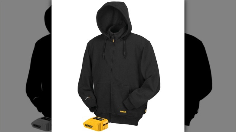 A black DeWalt heated hoodie with front zipper, hood, and pockets, shown with a yellow 20V MAX battery pack placed in front.