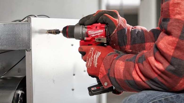 Person using Milwaukee hammer drill