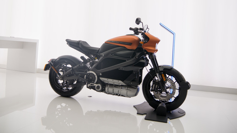 An orange and black Harley Livewire on display at an event