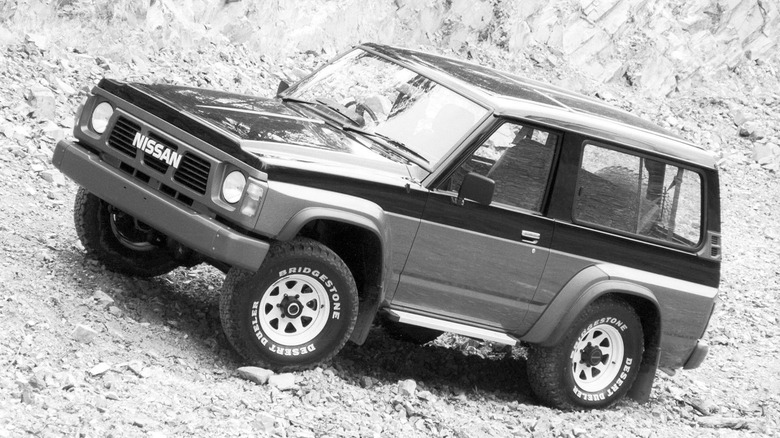 Nissan Patrol Y60 front 3/4 view while off-roading black and white image