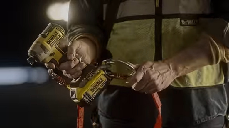 Person attaching carabiner to impact driver