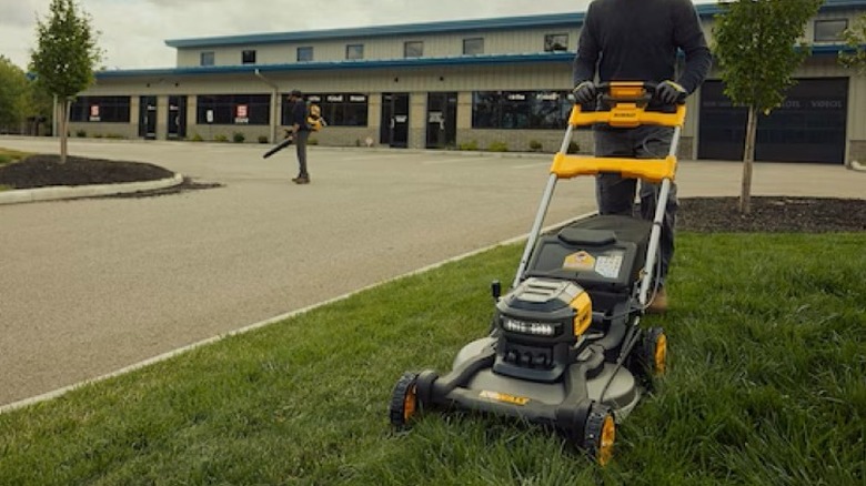 Person using DeWalt lawn mower on grass