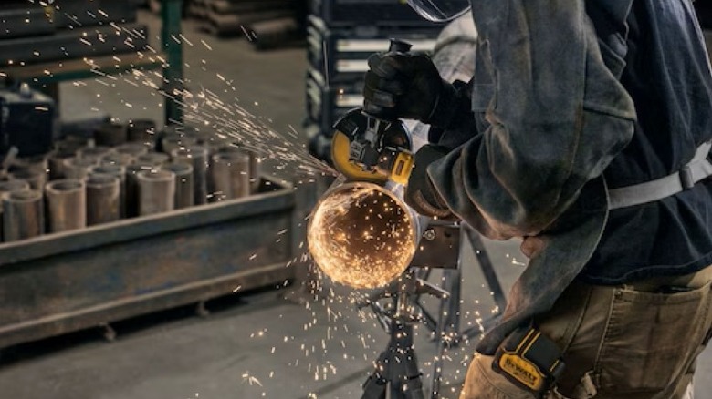 Person cutting the end off a pipe with a grinder tool