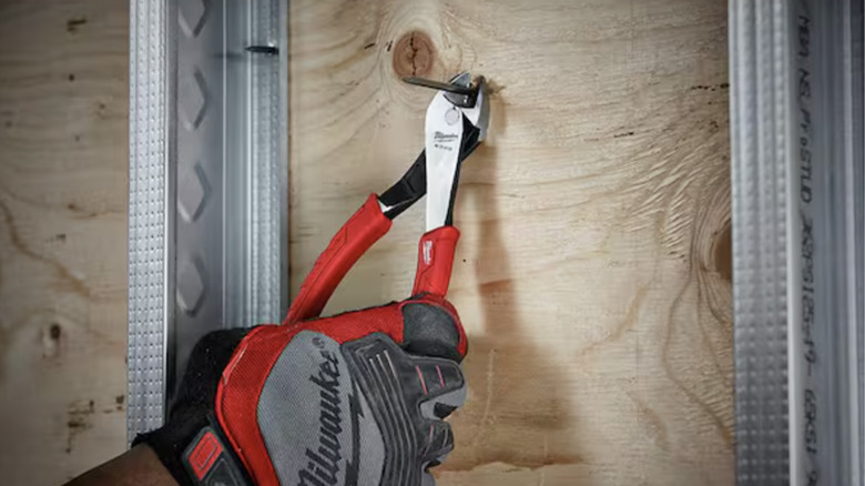 A person using pliers to snip a nail