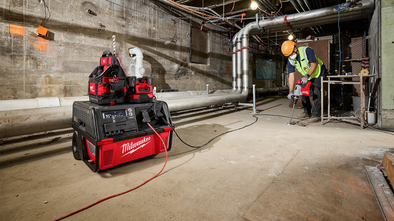 A construction worker doing work with a power supply nearby