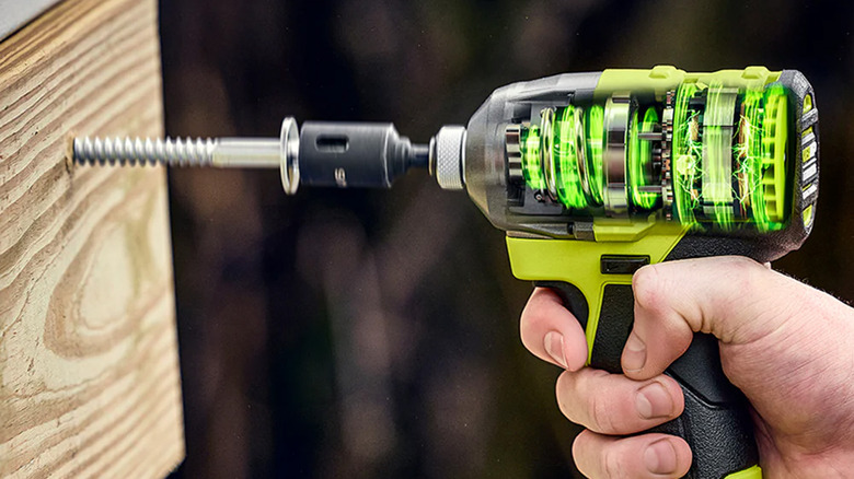 A Ryobi drill drilling a screw into some wood.