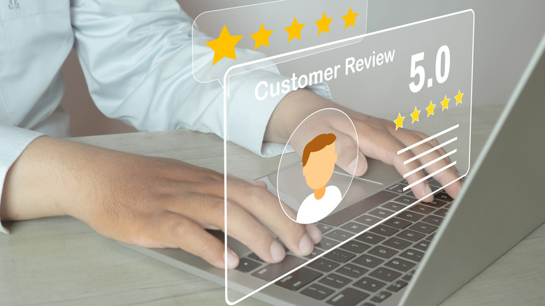 Image of a person typing a 5 star review on a laptop