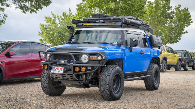 A blue Toyota FJ cruiser, mark one generation kitted out with a range of aftermarket mods