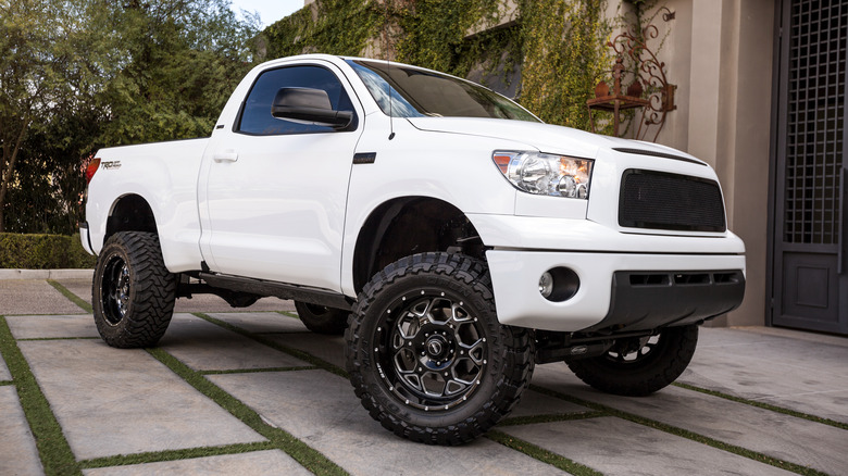 An older generation Toyota Tacoma parked in front of a house