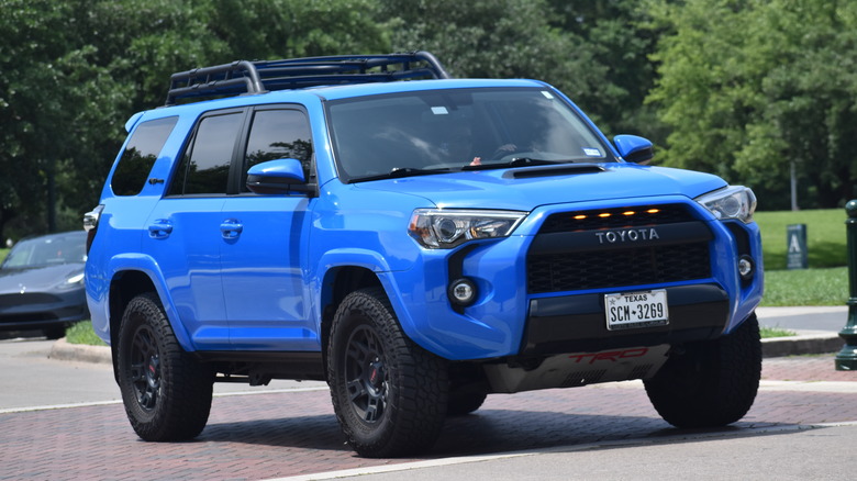 An electric Blue Toyota 4Runner moving down a side road