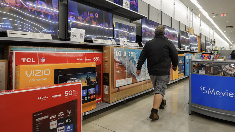 Customer walking by TVs in Walmart