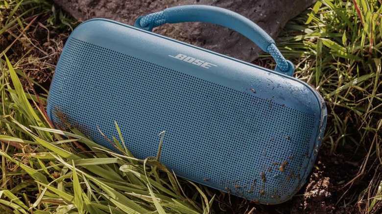 A Bose SoundLink Max speaker outside in the dirt