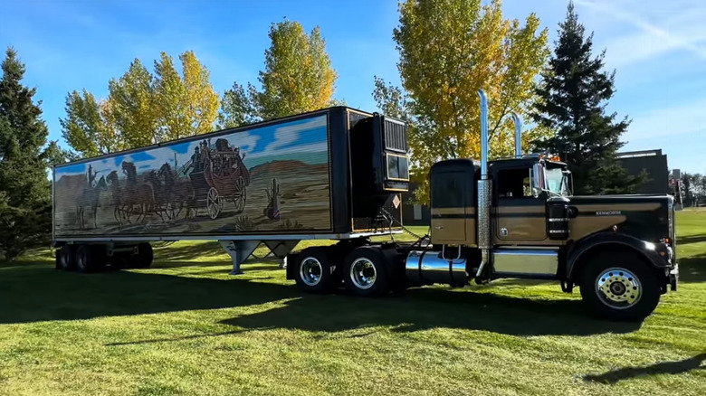 A Smokey and the Bandit tribute truck with a custom painted trailer, sitting on a grassy lawn.