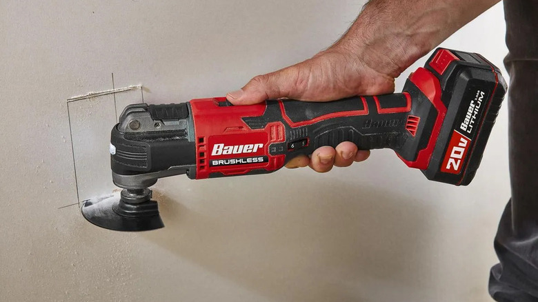 Bauer oscillating multi-tool cutting a hole in drywall