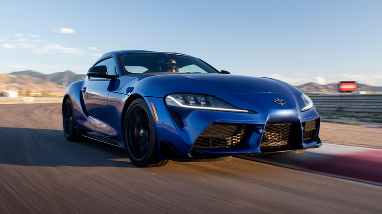 A Blue 2025 Toyota GR Supra driving on a racetrack