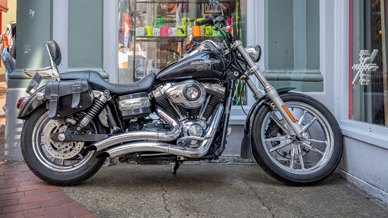 A Harley-Davidson Dyna Super Glide Custom parked in front of a shop.