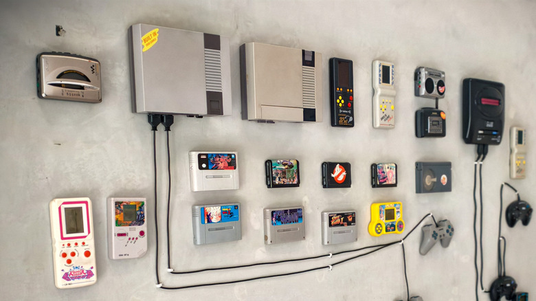 collection of retro gaming consoles on grey floor