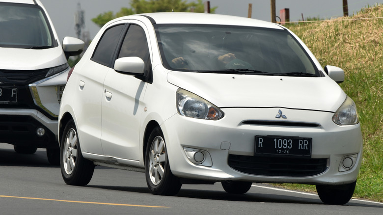 White Mitsubishi Mirage driving on a road