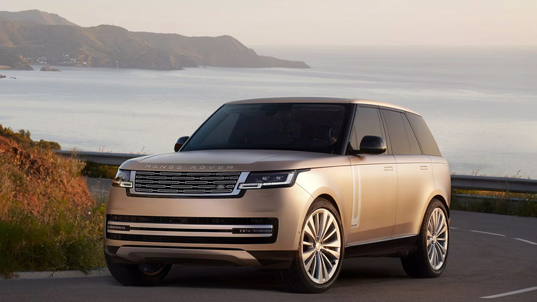 A bronze 2025 Land Rover Range Rover driving along the coast
