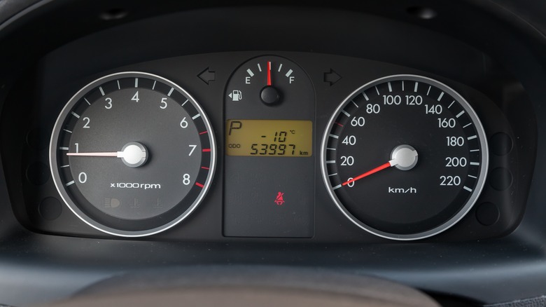 Close up of a car dashboard with mostly analog gauges