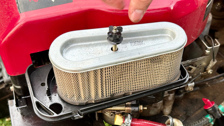 Air filter inspected by lawn mower user