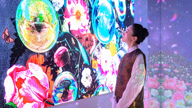 An 8K TV from Samsung being admired by a person in a showroom.